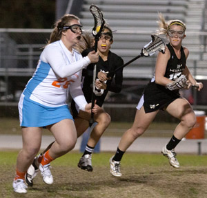 CHECK IT.  After receiving a pass, senior Melinda Rose runs away from her Bishop Moore opponents. The girls lost 15-14 against Bishop Moore.