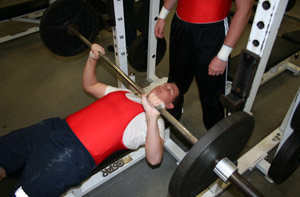 HEAVY LIFTING.  Before the match against Winter Park, freshman Steven Treu prepares to bench press. “My favorite parts are just getting into shape, learning responsibility and team work,” Treu said. Treu’s personal best of the clean and jerk and bench press 375 total.The boys won the match. 