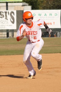 SAFE. In the game against Freedom, junior Blake Sanderson runs to third base.