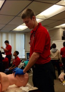 MOUTH TO MOUTH. Austin Fields practices resuscitation on a CPR dummy. photo courtesy/ AUSTIN FIELDS