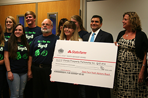 INVEST. Students in the Academy of Finance pose with agents from State Farm holding a grant for $67,000. photo/ LIZZY GORDON