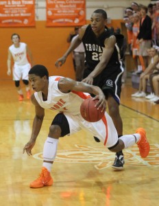 FAKE OUT.  Dribbling towards the basket, senior Berry Taylor attempts to take the ball to the hoop.