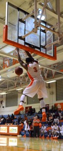 SLAM DUNK. Hanging from the hoop, senior Barry Taylor  completes a dunk and scores the winning points. photo/COURTNEY PATZ