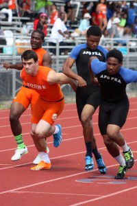 Sprint.  During the 4x100 meter relay, senior Stephen Brock is handed the baton.  photo/SAM HOLLEMAN