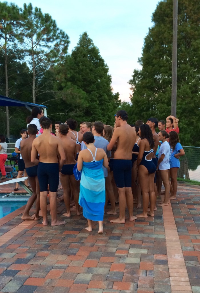 GATHER AROUND.  Boys and girls swim team huddle for a team meeting after the swim meet.  photo/Mary Grace Paris