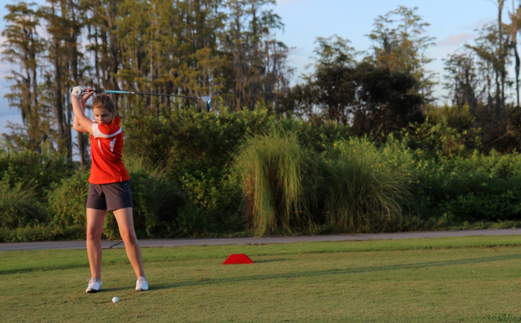 GET READY. Freshman Delaney Bookhardt swings back while she drives.