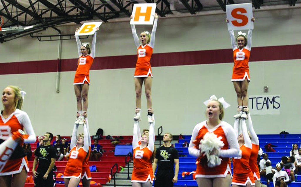 BHS. The cheer team sticks their opening stunt with signs abbreviating Boone High School. photo/Abby Hutsell 
