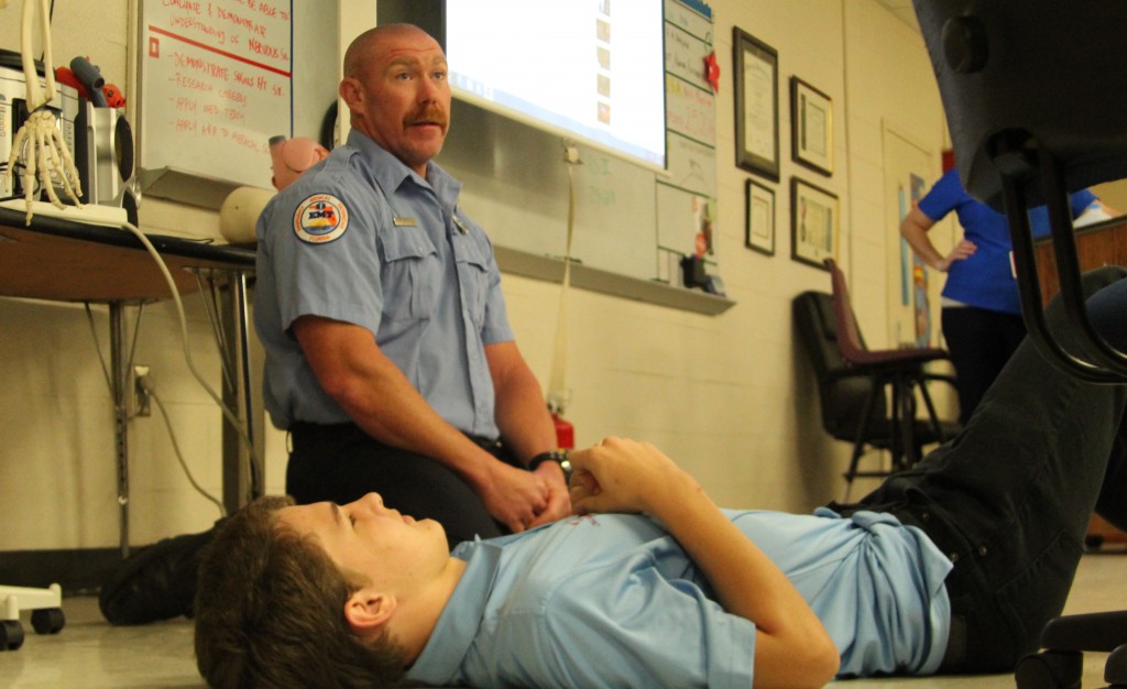 LISTEN UP. Paramedic Mike McGurk uses freshman Brogan Foskett to teach a Medical Skills class how to do compressions. photo/ Chasity Maynard
