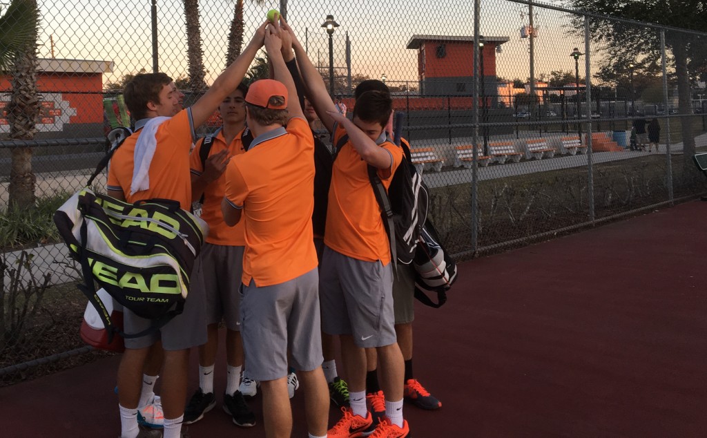 HANDS UP: Boy's tennis celebrates after their victory against rival Edgewater. 