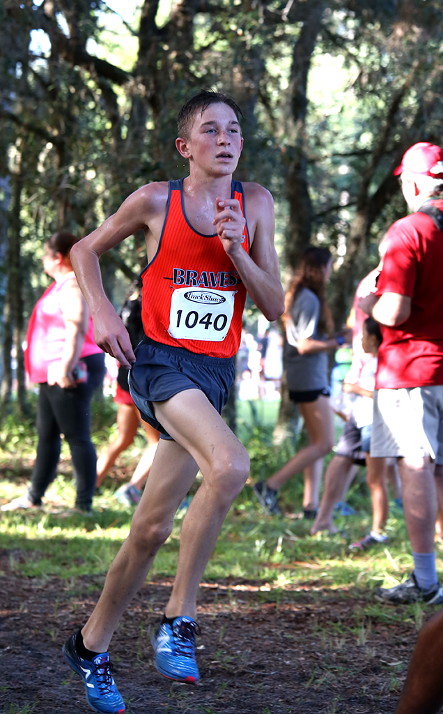 RUN JAKE RUN. While competing at the Hagerty Invitational, sophomore Jake Colvin jogs around a curve. photo/Mady Benton