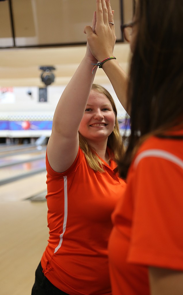 GIVE ME FIVE. Junior Aubrey Powers gives her teammate a high five to celebrate her strike. photo/ Renn Oberdick