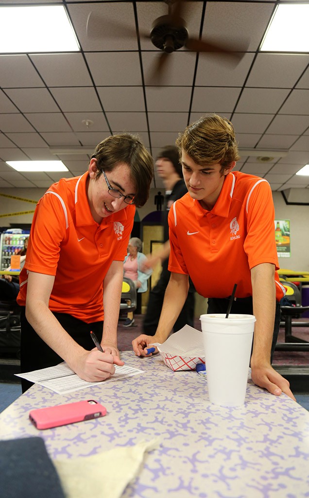 RECORD KEEPERS. Junior Alexander Betros and sophomore Bruce Stapleton track the team's scores throughout the match.