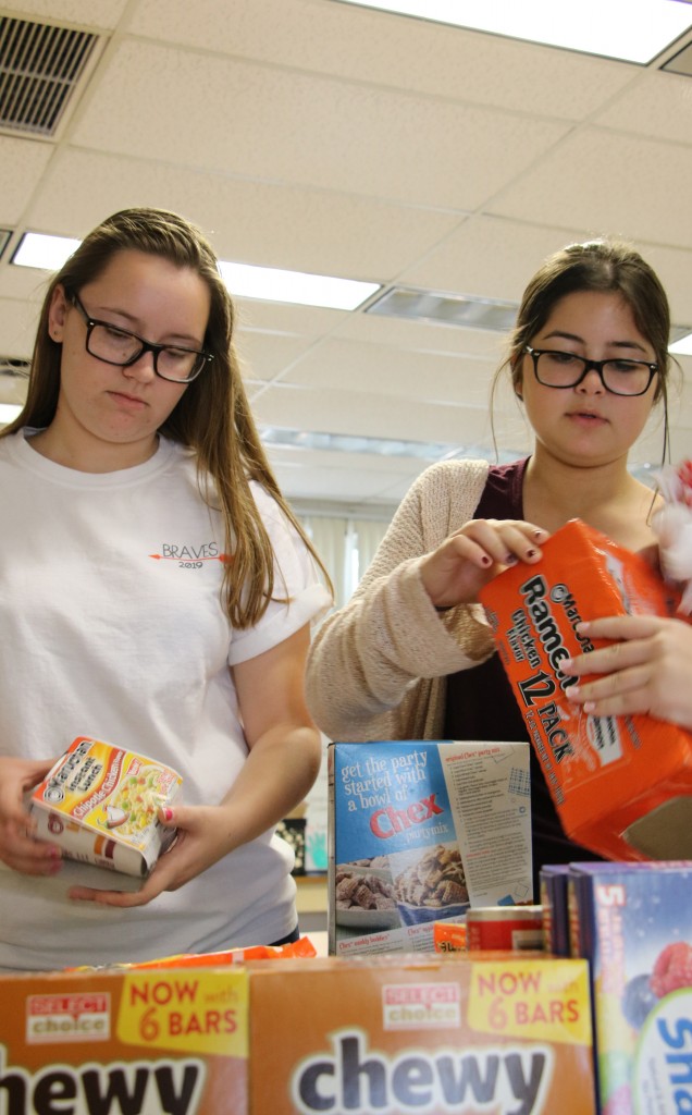 EAT UP. In fifth period, sophomore Rhyan Granger and freshman Juliette Paymayesh collect donations. photo/Sofia McGrover