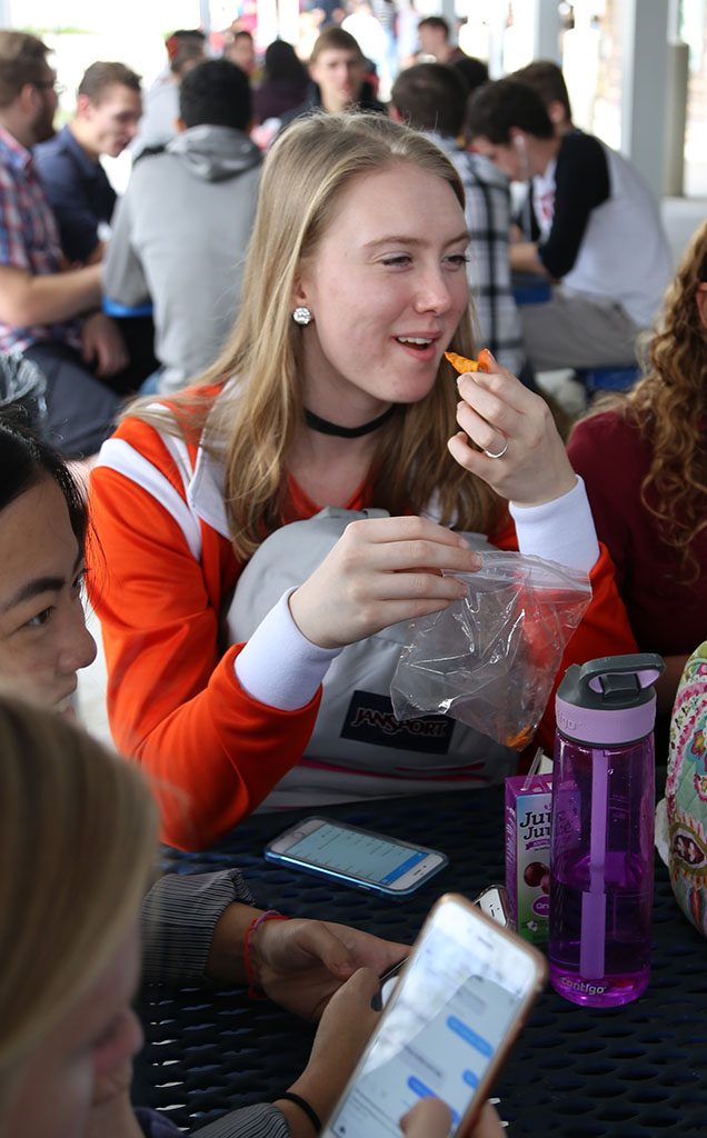 SNACK ATTACK. At lunch, junior Lily Tackzak enjoys a bag of Doritos. photo/ Sydney Schad