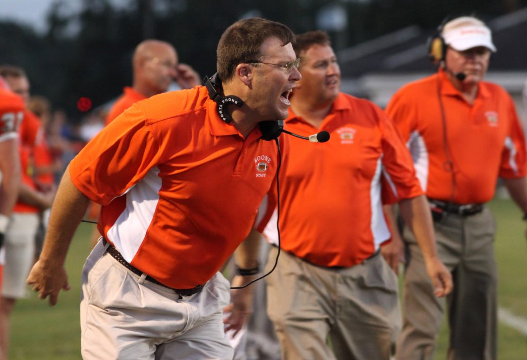 Football coach yells to players on the field